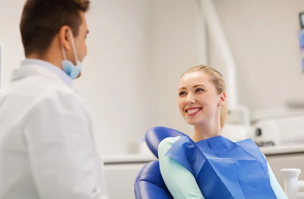 Dentista masculino feliz con paciente mujer en la clínica — Foto de Stock