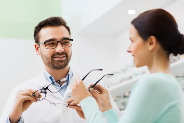 Frau und Optikerin zeigen Brille im Optikgeschäft — Stockfoto