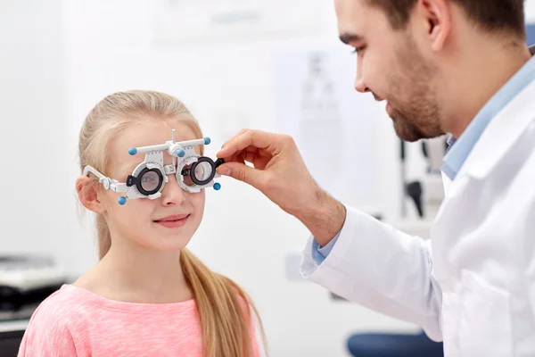 Optician with trial frame and girl at clinic — Stock Photo, Image