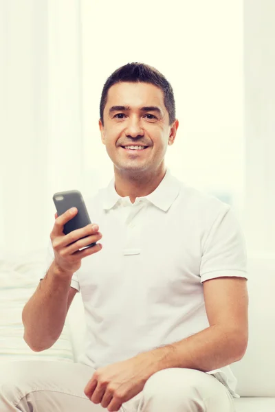 Hombre feliz con smartphone en casa — Foto de Stock