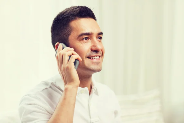 Glücklicher Mann, der zu Hause mit dem Smartphone telefoniert — Stockfoto