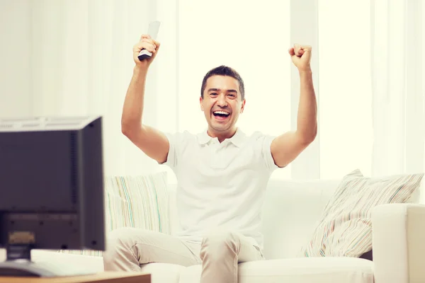 Uomo sorridente guardando gli sport a casa — Foto Stock