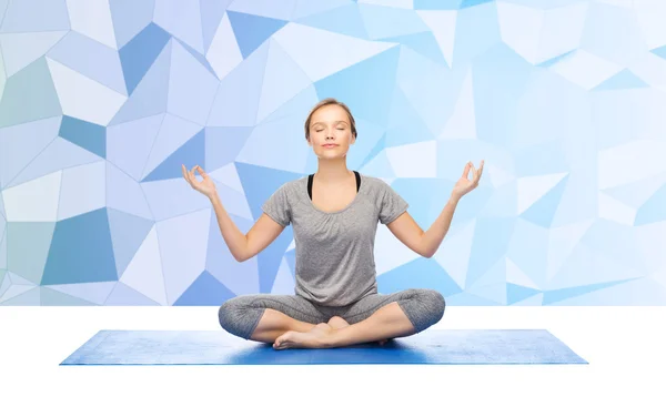 Donna che fa meditazione yoga in posa di loto sul tappeto — Foto Stock