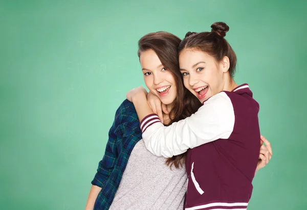 Niñas adolescentes felices abrazándose sobre tablero verde —  Fotos de Stock