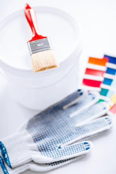 Paintbrush, paint pot, gloves and pantone samples — Stock Photo, Image