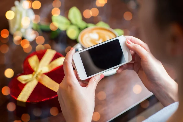 Close up of hands with smartphone, gift and coffee — Zdjęcie stockowe