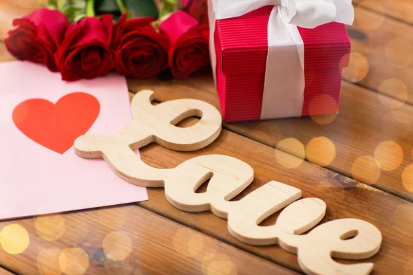 Nahaufnahme von Geschenkbox, roten Rosen und Grußkarte — Stockfoto