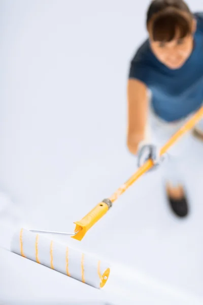 Vrouw met roller en verf kleuren van de muur — Stockfoto