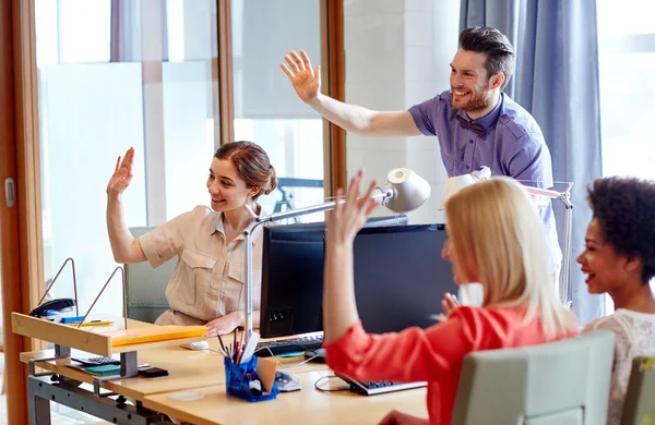 Lyckliga kreativa team viftande händer i office — Stockfoto