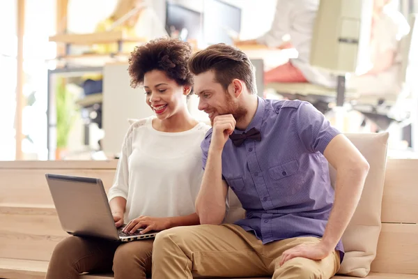 Happy creative team with laptop in office — Stock Photo, Image