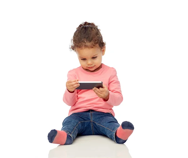 Sorrindo pequena menina brincando com smartphone — Fotografia de Stock