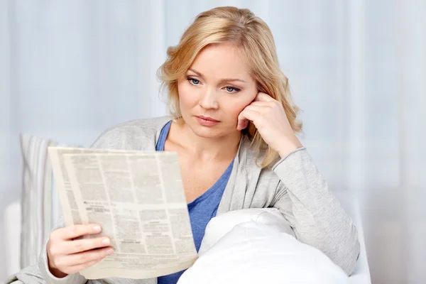 Жінка читає газету вдома Ліцензійні Стокові Зображення