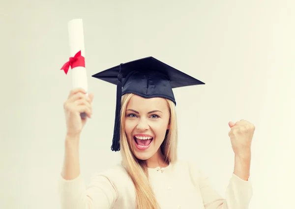 Student in afstuderen cap met certificaat — Stockfoto