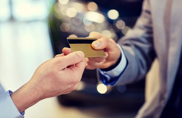 Customer giving credit card to car dealer in salon — Stock Photo, Image