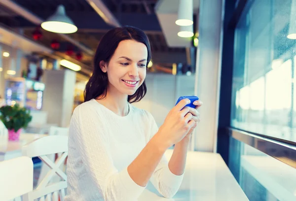 Smiling woman with smartphone at cafe — Stock Photo, Image