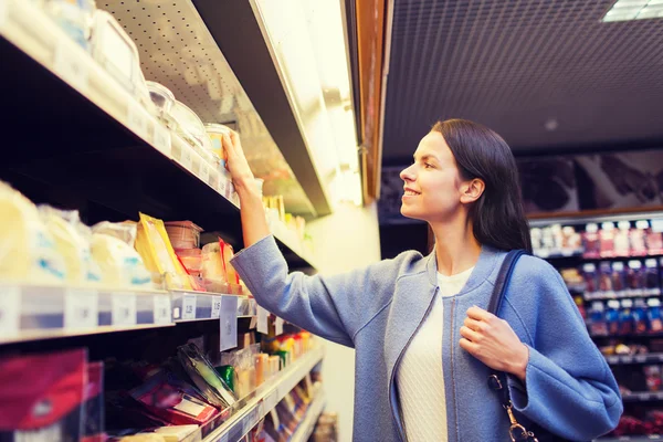 Gelukkige vrouw kiezen en kopen van voedsel in de markt — Stockfoto