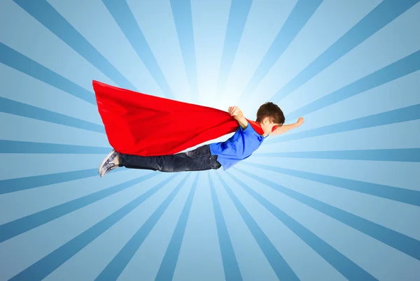 Anak laki-laki berjubah superhero merah dan topeng terbang di udara — Stok Foto