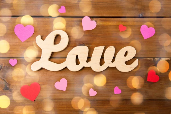 Close-up de amor palavra com corações de papel vermelho — Fotografia de Stock