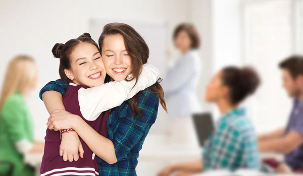 Glückliche Teenager-Studentinnen, die sich in der Schule umarmen — Stockfoto