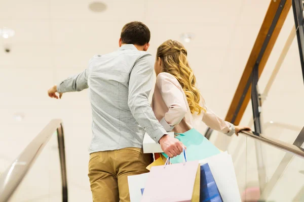 Boldog fiatal pár bevásárló táskák a plázában — Stock Fotó