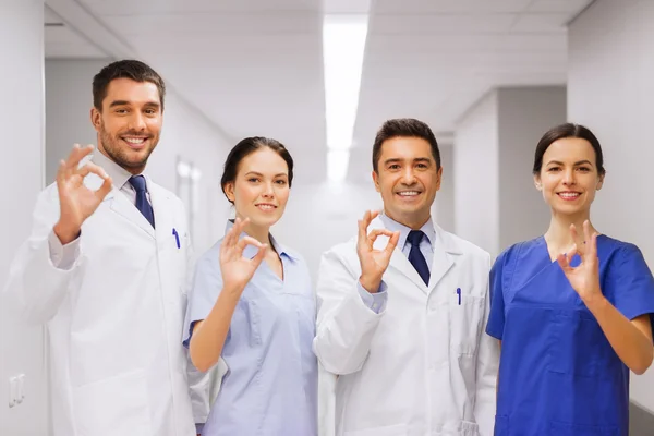 Gruppo di medici in ospedale mostrando segno mano ok — Foto Stock