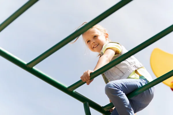 Fröhliches kleines Mädchen klettert auf Kinderspielplatz — Stockfoto