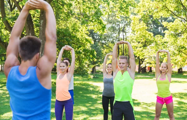 Group of friends or sportsmen exercising outdoors — Stock Photo, Image