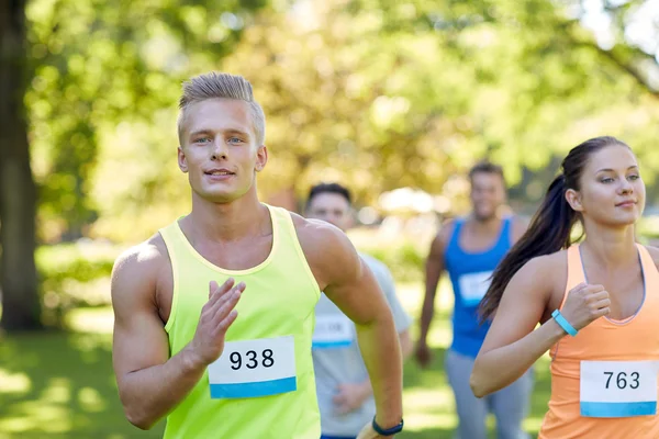 Feliz joven deportistas carreras ingenio insignia números — Foto de Stock