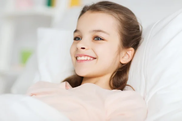 Szczęśliwy uśmiechający się dziewczyna leżąc wzbudzić w łóżku w domu — Zdjęcie stockowe