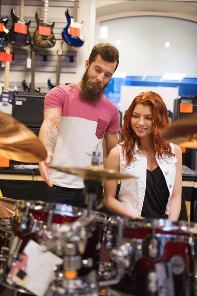 Hombre y mujer con kit de batería en la tienda de música —  Fotos de Stock