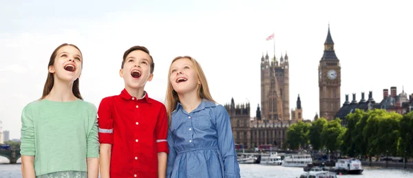 Amazed boy and girls looking up over london — Stock Photo, Image