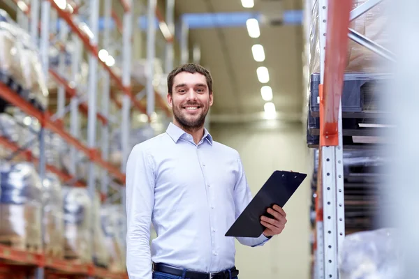 Happy businessman with clipboard at warehouse — Stock Photo, Image