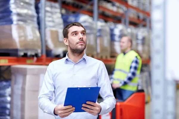 Businessman with clipboard at warehouse — Stock Photo, Image