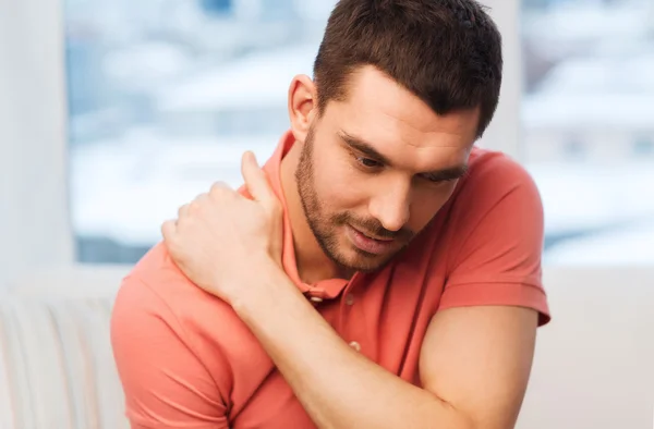 Nieszczęśliwy człowiek cierpiący na ból szyi w domu — Zdjęcie stockowe