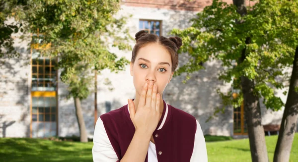 Verward student meisje die betrekking hebben op haar mond met de hand — Stockfoto