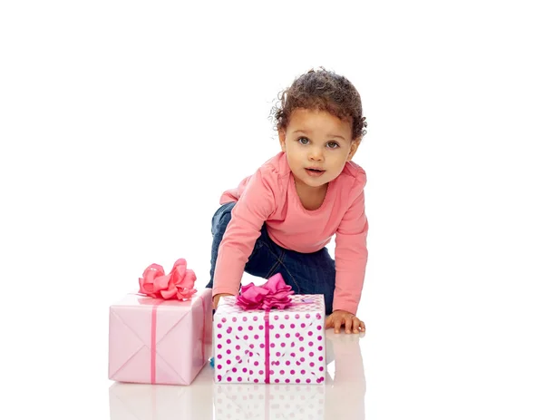 Baby girl with birthday presents and confetti — Stock Photo, Image