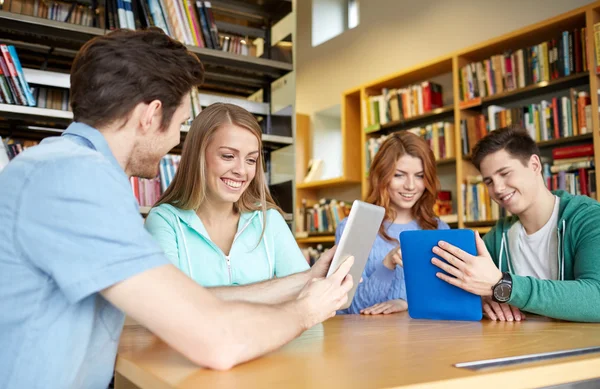 Zadowoleni uczniowie z komputera typu tablet w bibliotece — Zdjęcie stockowe