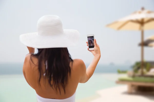 Kvinnan tar selfie med smartphone på stranden — Stockfoto