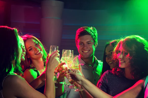 Lachende vrienden met glazen van champagne in club — Stockfoto