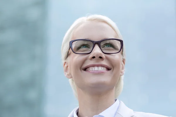 Joven mujer de negocios sonriente sobre edificio de oficinas — Foto de Stock