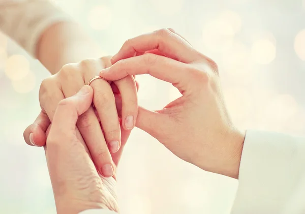 与婚戒亲密接触的女同性恋夫妇的手 — 图库照片