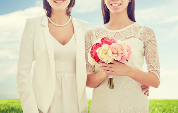 Close up de feliz casal lésbico com flores — Fotografia de Stock