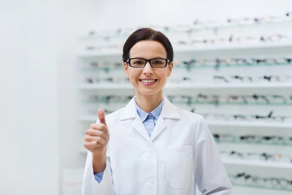 Woman in glasses with thumbs up at optics store — 스톡 사진