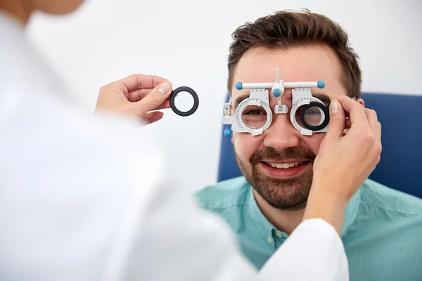 Optician with trial frame and patient at clinic — Stock Photo, Image