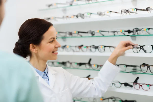 Optiker visar glasögon till människan på optik butik — Stockfoto