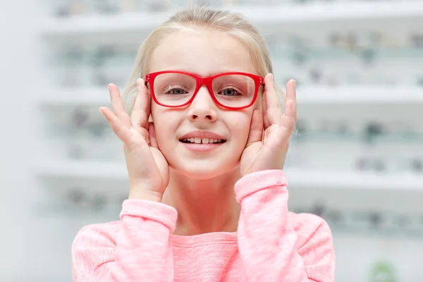 Niña en gafas en la tienda de óptica — Foto de Stock