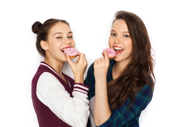 Happy pretty teenage girls eating donuts — Stock Photo, Image