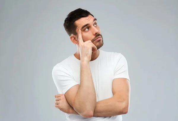 Homme réfléchissant sur fond gris — Photo