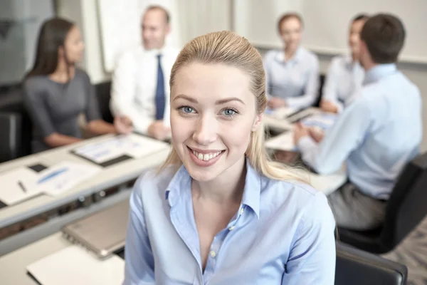 Группа улыбающихся бизнесменов, встречающихся в офисе — стоковое фото