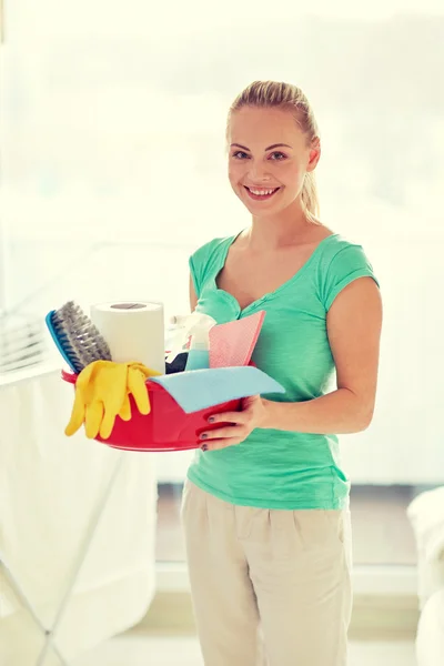 Mujer feliz sosteniendo cosas de limpieza en casa —  Fotos de Stock